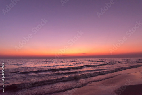 Nature in twilight period which including of sunrise over the sea and the nice beach. Summer beach with blue water and purple sky at the sunset.