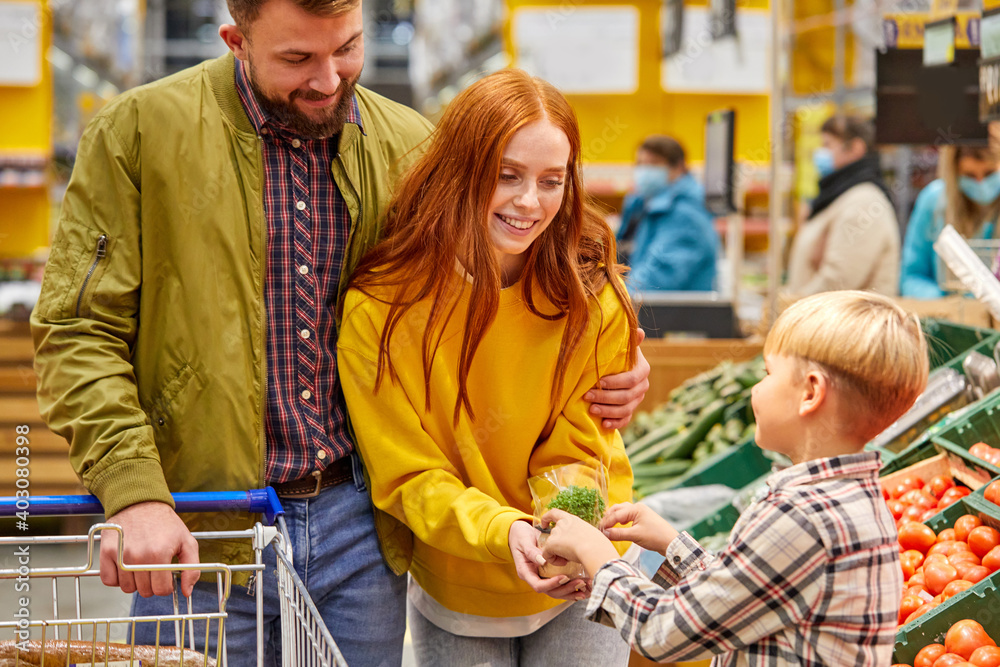 parents and child in supermarket, caucasian married couple buy fresh food in grocery store.family in shop
