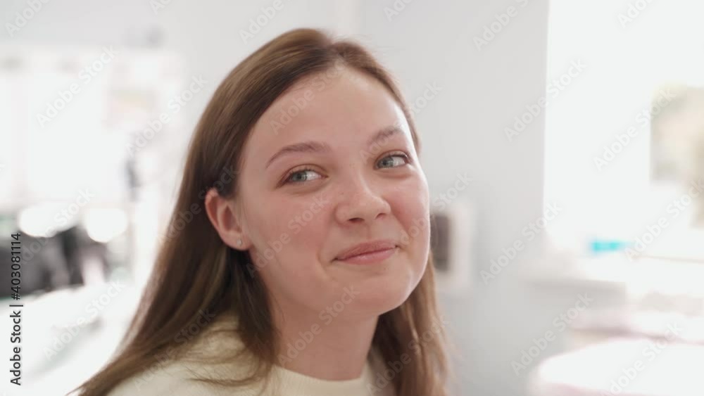 Young cheerful woman laughs and gestures in a bright room. Young cheerful woman laughs and gestures in a bright room.