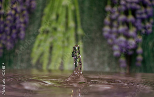 Water drop with lavender in background.