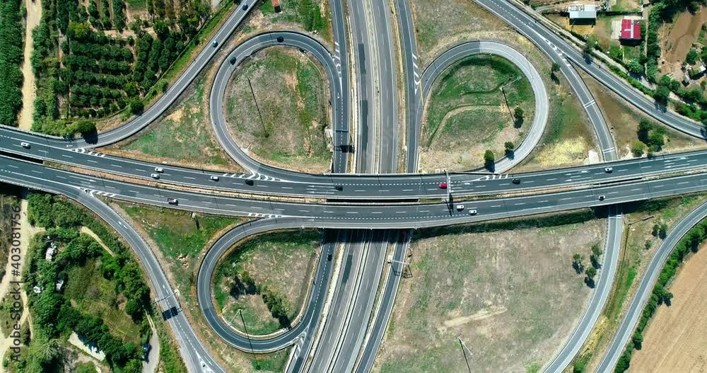 Beautiful aerial view with a drone of an interchange in Spain. There is agricultural fields all around the busy traffic 4K Beautiful aerial view with a drone of an interchange in Spain. There is agricultural fields all around the busy traffic 4K