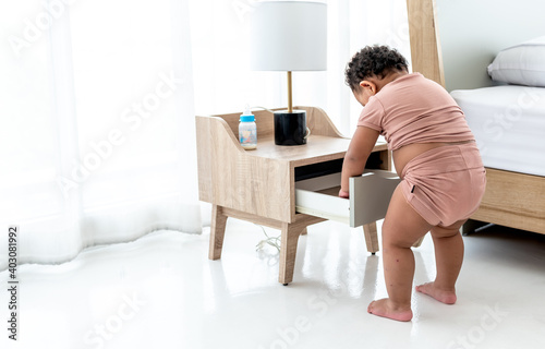 A 1-year-6-month age, demolishing the drawers of the bedside table, is mischievous and curious according to the child's age and development, to children learning concept. © Anatta_Tan