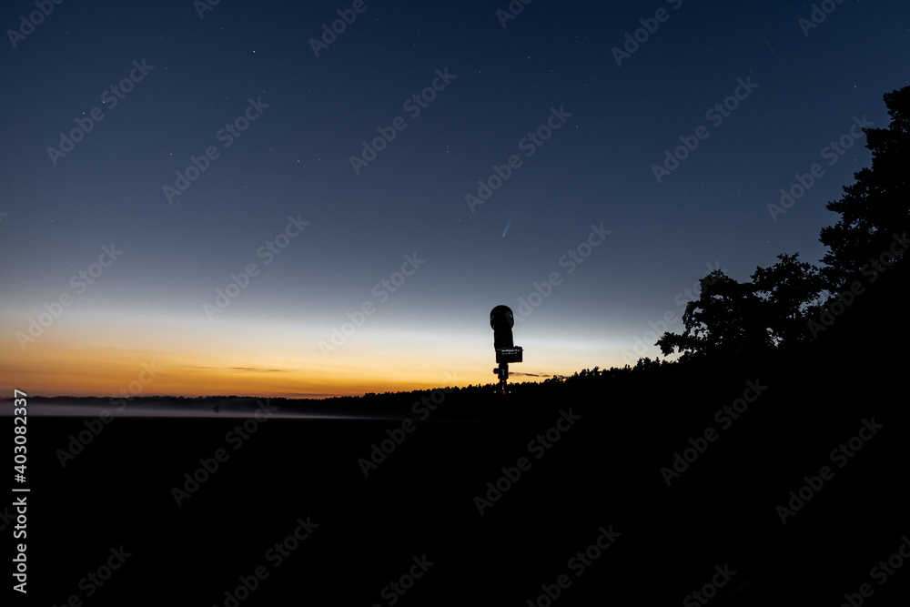 Komet Neowise am Abend mit einer Kamera im Vordergrund