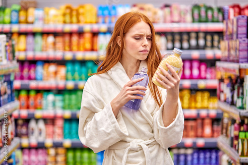 Slika na platnu female reading composition of bath salt in store, wearing bathrobe