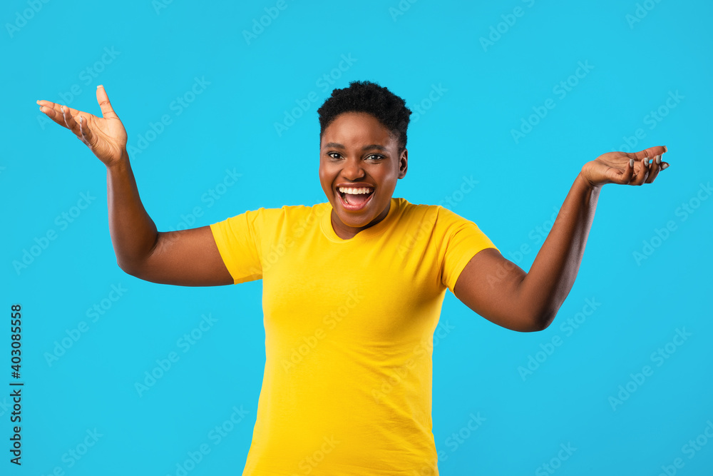 Joyful African Plus-Size Woman Posing With Raised Hands, Blue Background Joyful African Plus-Size Woman Posing With Raised Hands, Blue Background