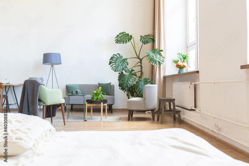 interior of stylish loft. spacious apartment with large windows, parquet on the floor and light walls. closeup view of shelving with different small things for decoration