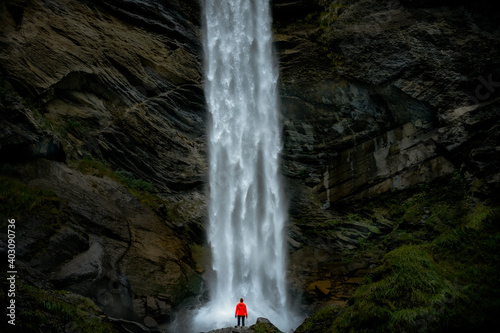 woman looks at a waterfall from below