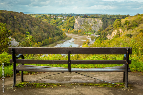 A view from Sion Hill looking down the Avon Gorge towards Avonmouth with a bench in the foreground on a bright Autumn day photo