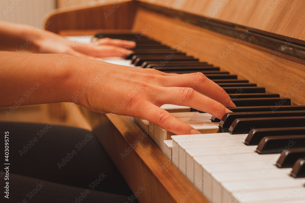 Fototapeta premium pianist playing the piano, close up view of hands and keys, side view