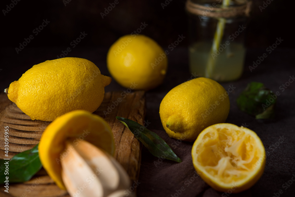 Ripe juicy organic lemons on a wooden board, dark background