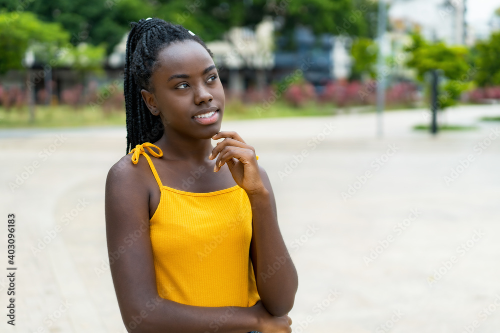 Fototapeta premium Beautiful african american young adult woman with braids thinking about the future