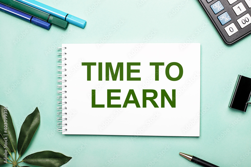 Fototapeta premium TIME TO LEARN is written on a white sheet on a blue background near the stationery and the Scheffler sheet. Call to action. Motivational concept