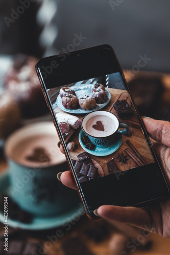 Woman taking picture with her smartphone at the cafe photo