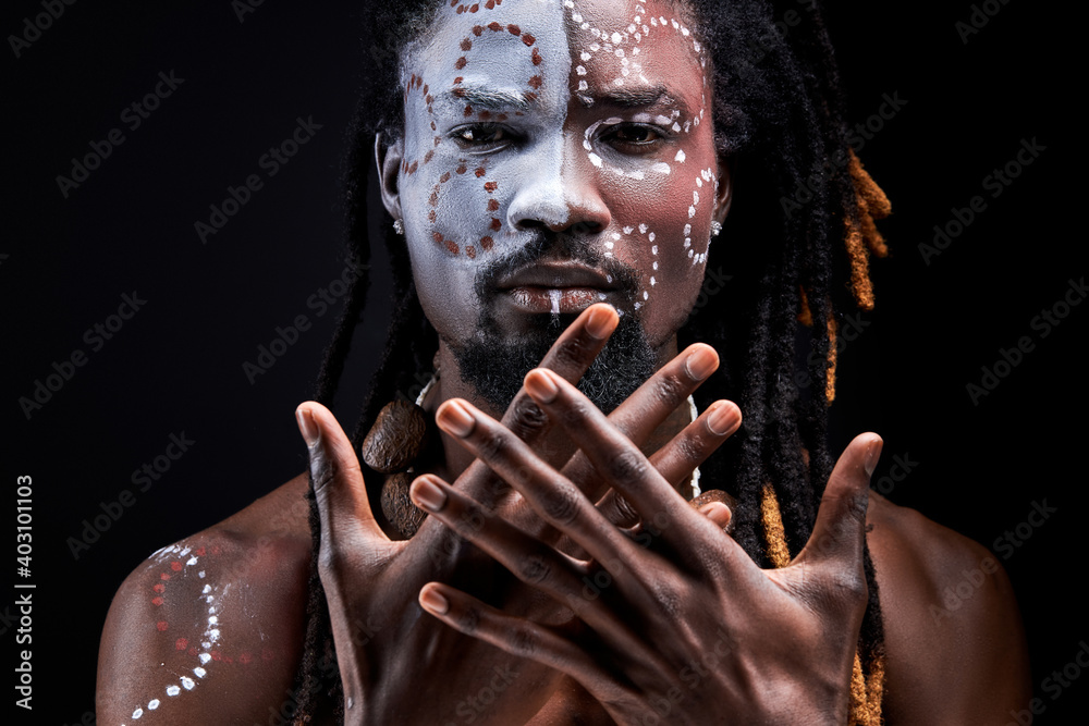 black male model doing ritual isolated over black background, portrait ...