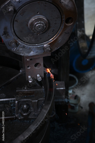 Manufacturing of bearings at the factory. Heavy industry concept. Sparks in bearing production. Metal product. Out of focus. Without people. Vertical photo.