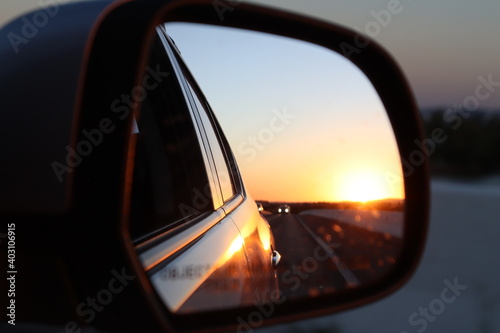 rear view photo of the car, where you can see the sunset on a highway