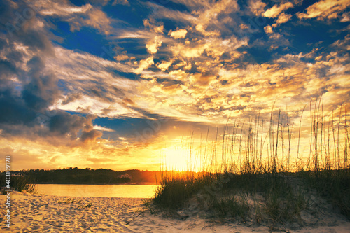 Sunset over the beach and dunes at Pawleys Island, SC, USA, looking across the inlet to the mainland.