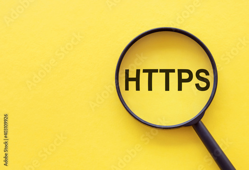 The word HTTPS is written on a magnifying glass on a yellow background.