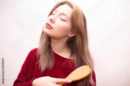 Girl combing hair isolated on white background