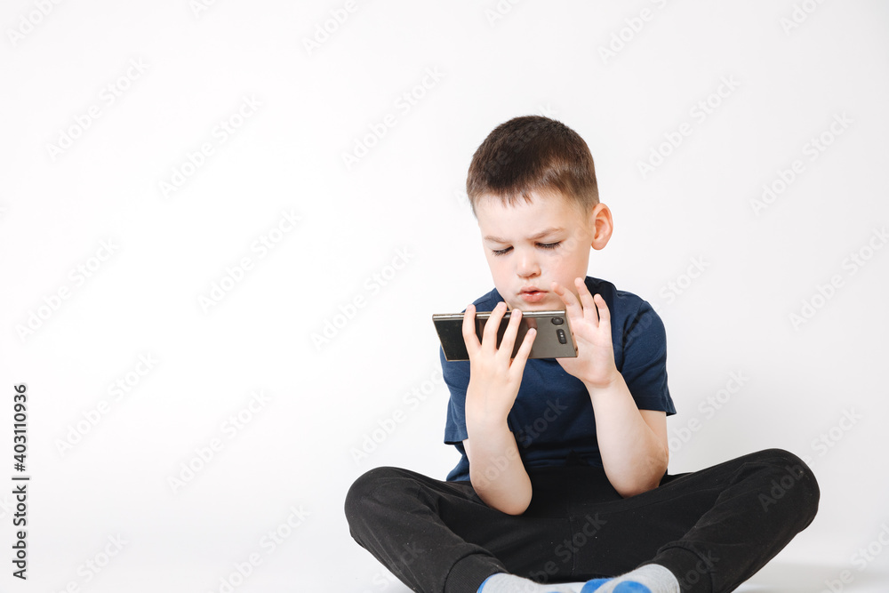 child playing with phone. little boy on white background playing with smartphone. Raising children. Children and digital media child playing with phone. little boy on white background playing with smartphone. Raising children. Children and digital media