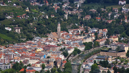 Panoramic view of Merano cityscape with its roofs, old church towers and Passer river seen from Marling city in South Tyrol, Italy