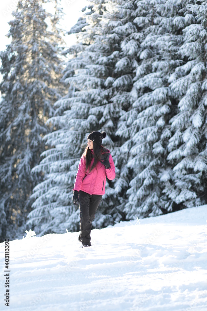 Girl on winter snowy fir tree background on ski resort