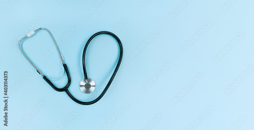 Black stethoscope on soft blue background. Simple flat lay with copy space. Black stethoscope on soft blue background. Simple flat lay with copy space.