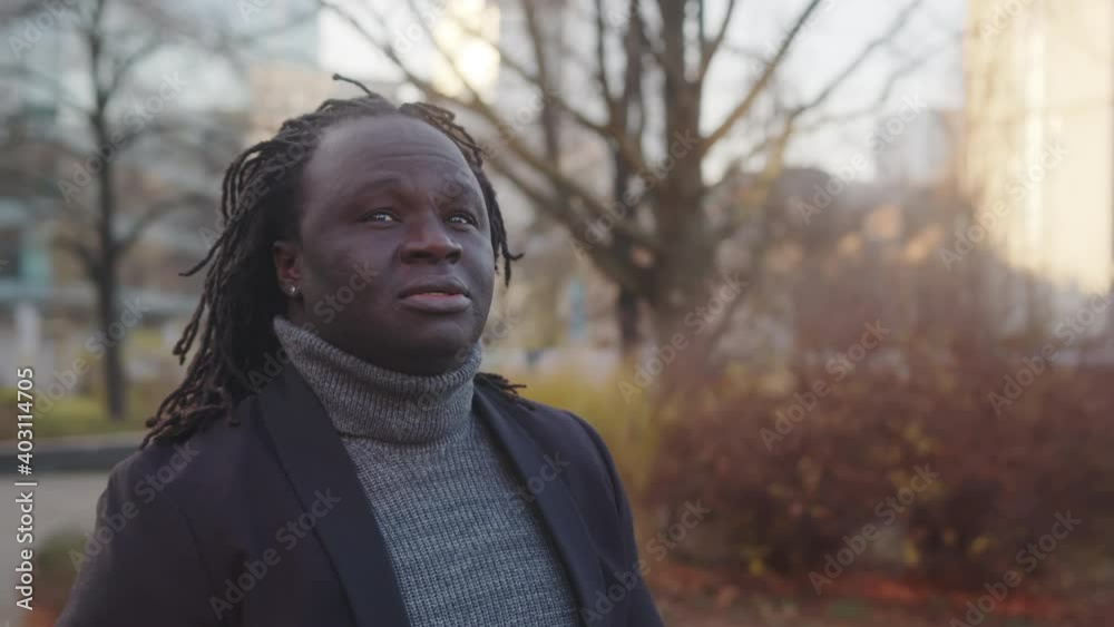 Portrait of african american black man with braided hair walking on the street and looking around. High quality 4k footage Portrait of african american black man with braided hair walking on the street and looking around. High quality 4k footage