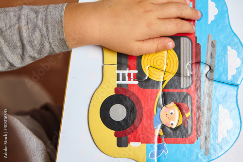 Child playing with puzzles,. The boy is playing in his room. Educational logic toys for kid's..