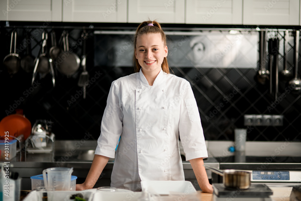 handsome young smiling woman chef at kitchen handsome young smiling woman chef at kitchen