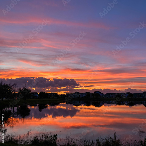 Beautiful pink, orange and blue sunset reflecting on a lake. © Joni