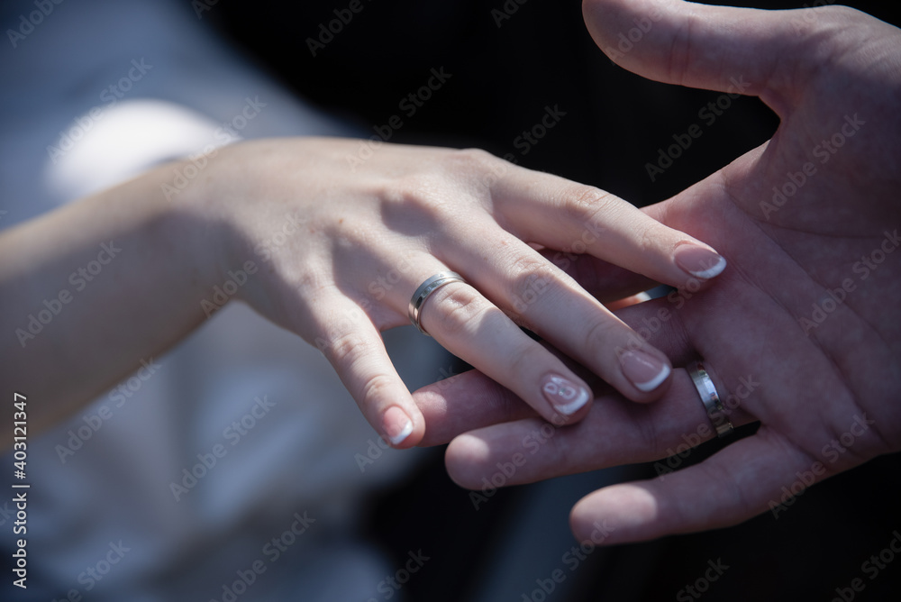 Happy groom helping his bride out of the wedding car. Elegant handsome stylish groom helping gently gorgeous bride, Closeup of holding hands with wedding rings. Happy groom helping his bride out of the wedding car. Elegant handsome stylish groom helping gently gorgeous bride, Closeup of holding hands with wedding rings.