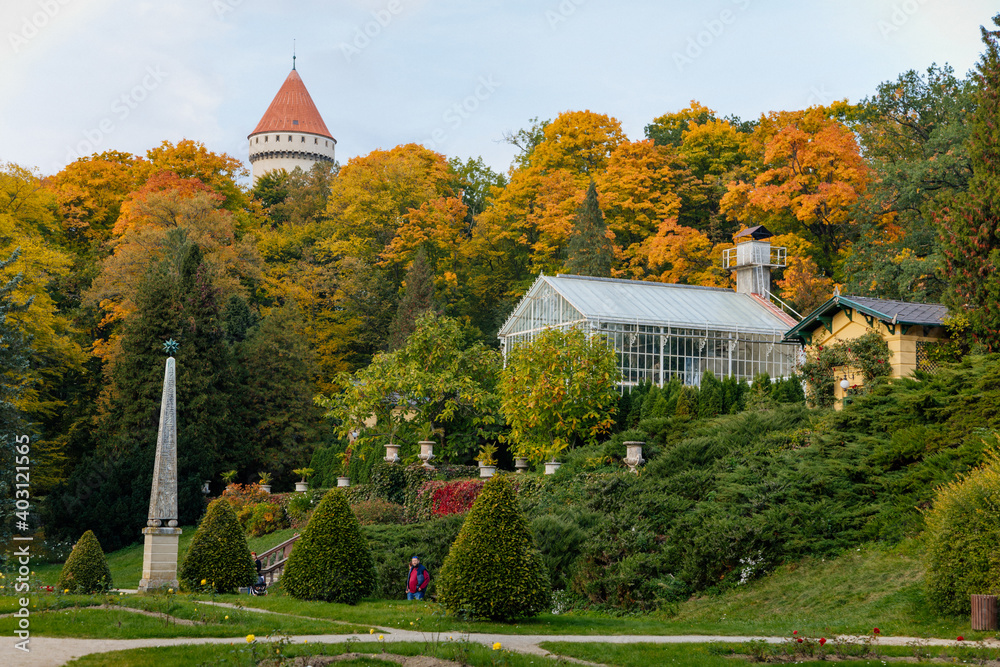 English-style park with glass greenhouse in autumn day, rose garden, statues near romantic medieval gothic and baroque castle Konopiste, Chateau at Central Bohemia, Czech Republic