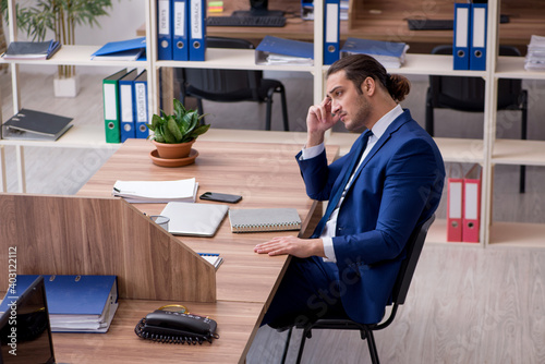 Foto Young male employee working in the office