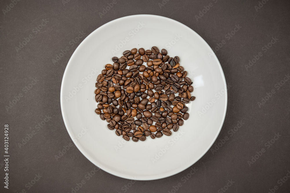Roasted coffee beans in a white plate Roasted coffee beans in a white plate