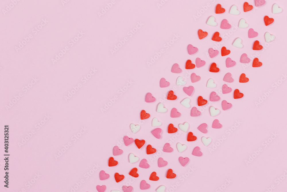 Heart shaped candies scattered on pink background Heart shaped candies scattered on pink background