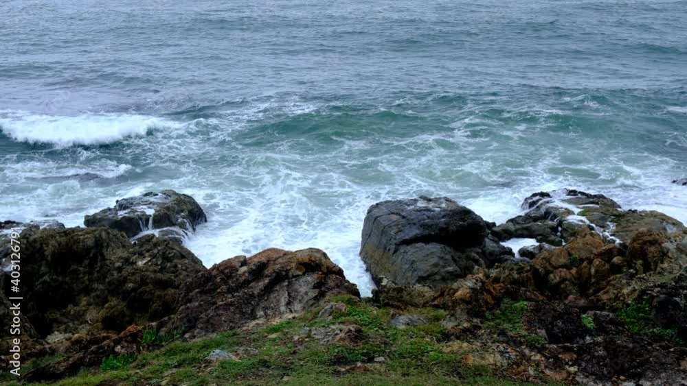Moody ocean crashes against rocks at Moonee Beach, Australia. Moody ocean crashes against rocks at Moonee Beach, Australia.