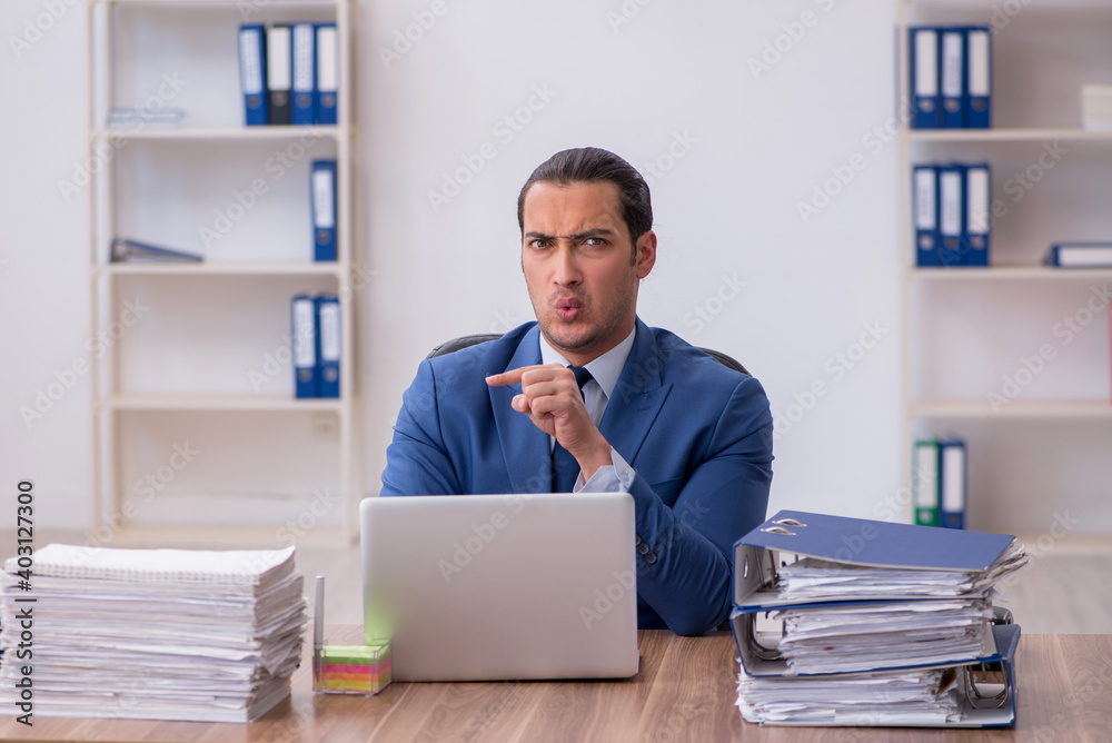 Young male employee unhappy with excessive work Young male employee unhappy with excessive work