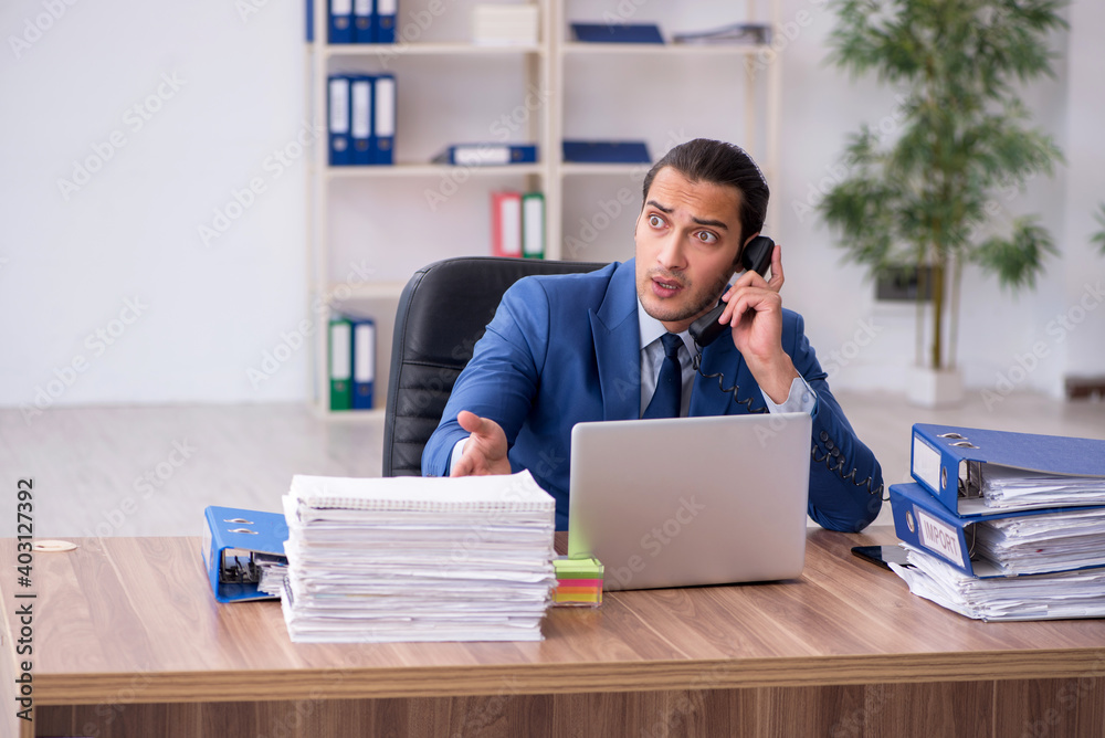 Young male employee unhappy with excessive work Young male employee unhappy with excessive work