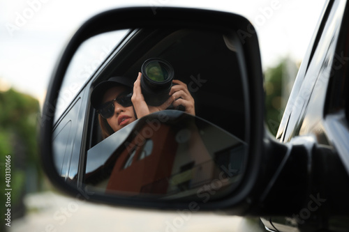 Private detective with camera spying from auto, view through car side mirror © New Africa