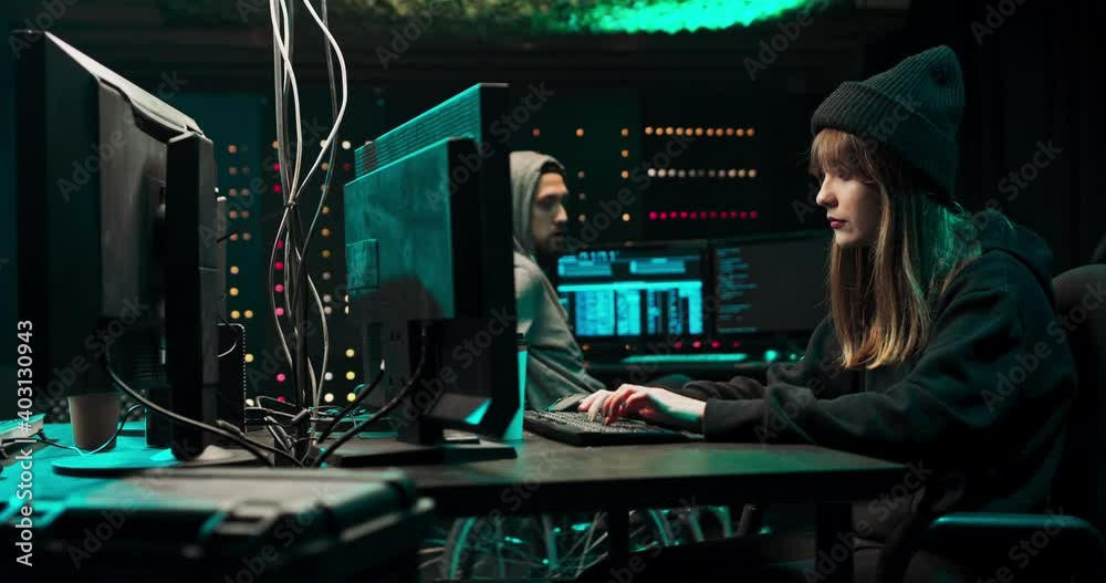 Team of Internationally Wanted Teenage Hackers Infect Servers and Infrastructure with Ransomware. Their Hideout is Dark and Has Multiple displays. One of the hackers is in a wheelchair. Team of Internationally Wanted Teenage Hackers Infect Servers and Infrastructure with Ransomware. Their Hideout is Dark and Has Multiple displays. One of the hackers is in a wheelchair.