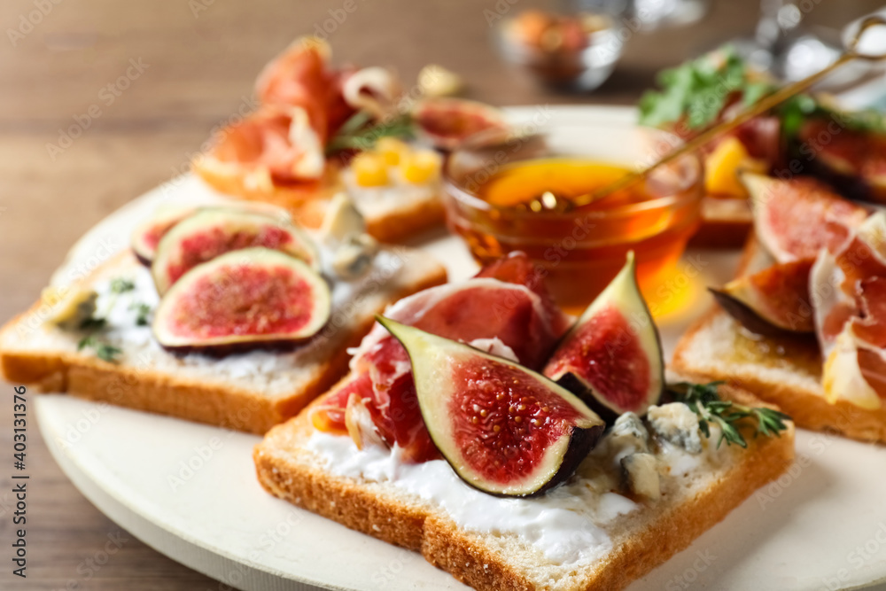 Sandwiches with figs, proscuitto and cheese on wooden table, closeup Sandwiches with figs, proscuitto and cheese on wooden table, closeup