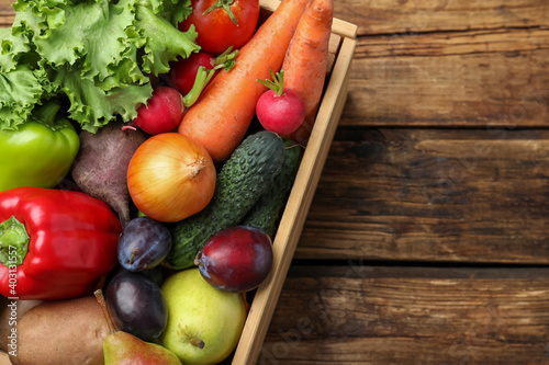 Fototapeta Naklejka Na Ścianę i Meble -  Crate full of different vegetables and fruits on wooden table, top view. Harvesting time