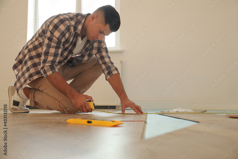 Professional worker installing new parquet flooring indoors Professional worker installing new parquet flooring indoors