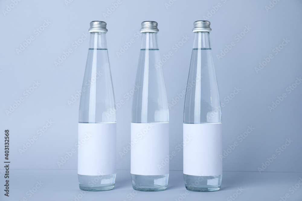 Glass bottles with soda water on light background Glass bottles with soda water on light background