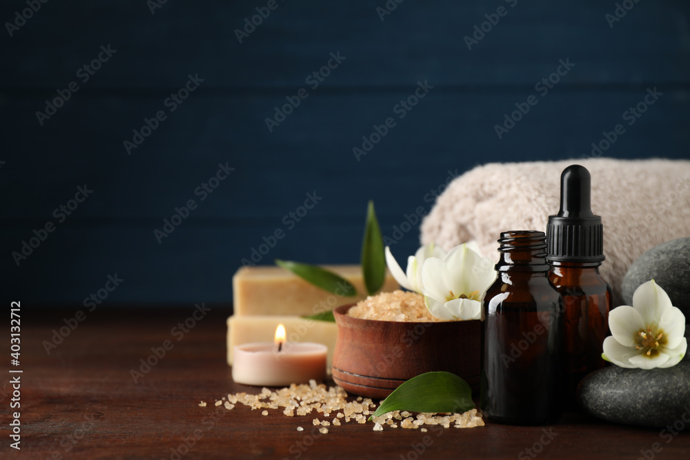 Composition with skin care products, spa stones and aroma oil on wooden table. Space for text Composition with skin care products, spa stones and aroma oil on wooden table. Space for text