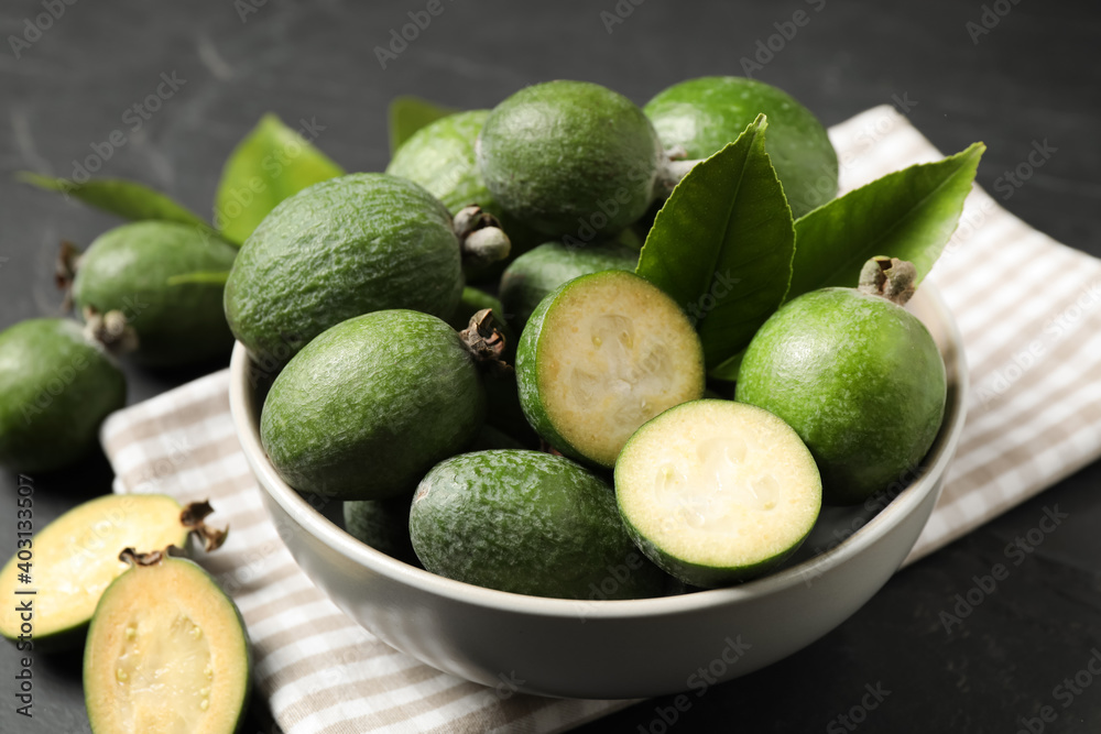 Fresh green feijoa fruits in bowl on black table, closeup Fresh green feijoa fruits in bowl on black table, closeup