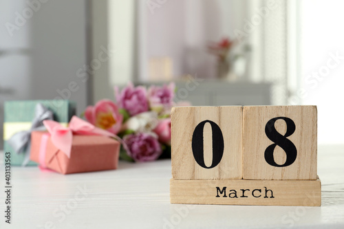 Wooden block calendar with date 8th of March on table indoors, space for text. International Women's Day
