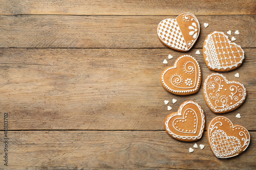 Tasty heart shaped gingerbread cookies on wooden table table, flat lay. Space for text