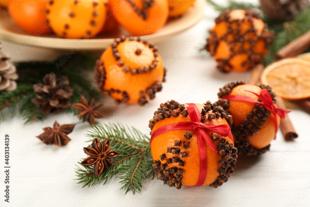 Pomander balls made of fresh tangerines with cloves  on white wooden table. Christmas atmosphere